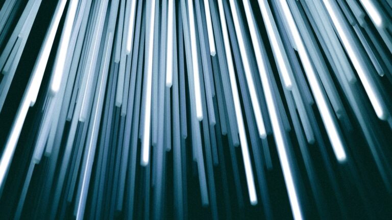 Feixes de fibra óptica iluminados em tons de azul e branco sobre fundo escuro, vistos, imagem ilustrativa do artigo sobre Bens digitais da empresa na sucessao do socio: dominio,